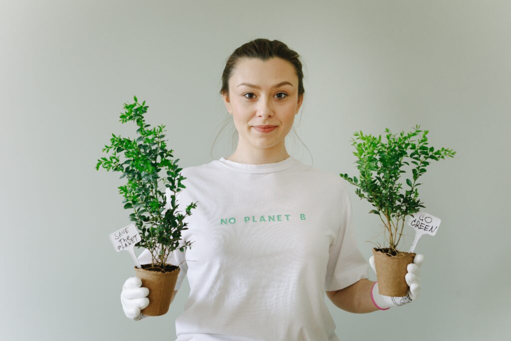 Shows a woman with plants in her hand, indicating a change for the planet is needed.
